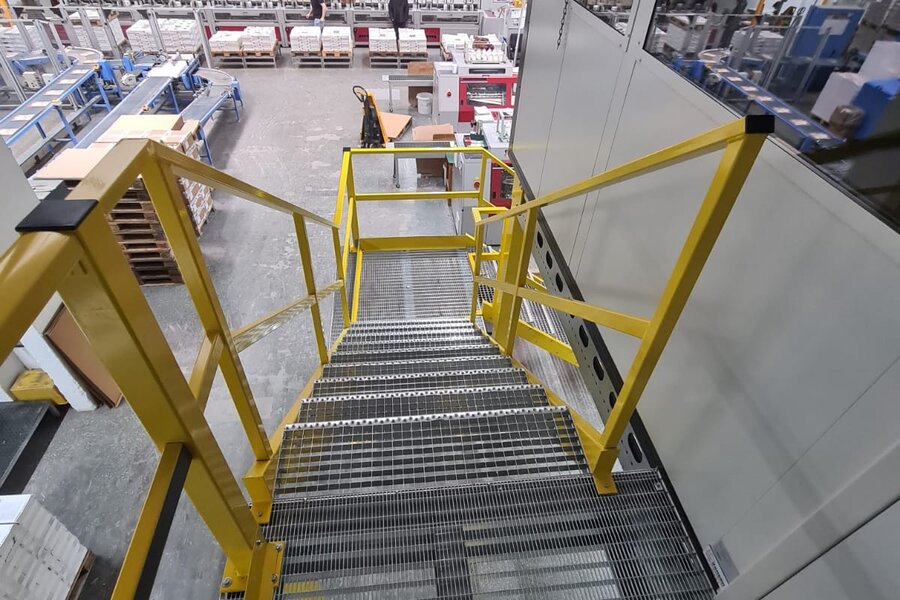 Gelbe Treppe, welche an Stahlbühne befestigt ist